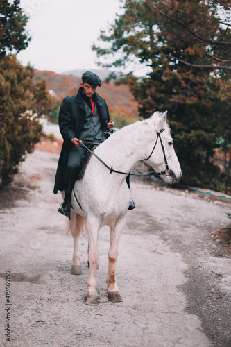 Stylish guy on a white horse