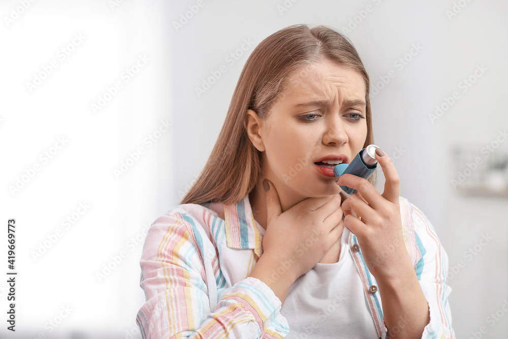 Young woman with inhaler having asthma attack at home Young woman with inhaler having asthma attack at home