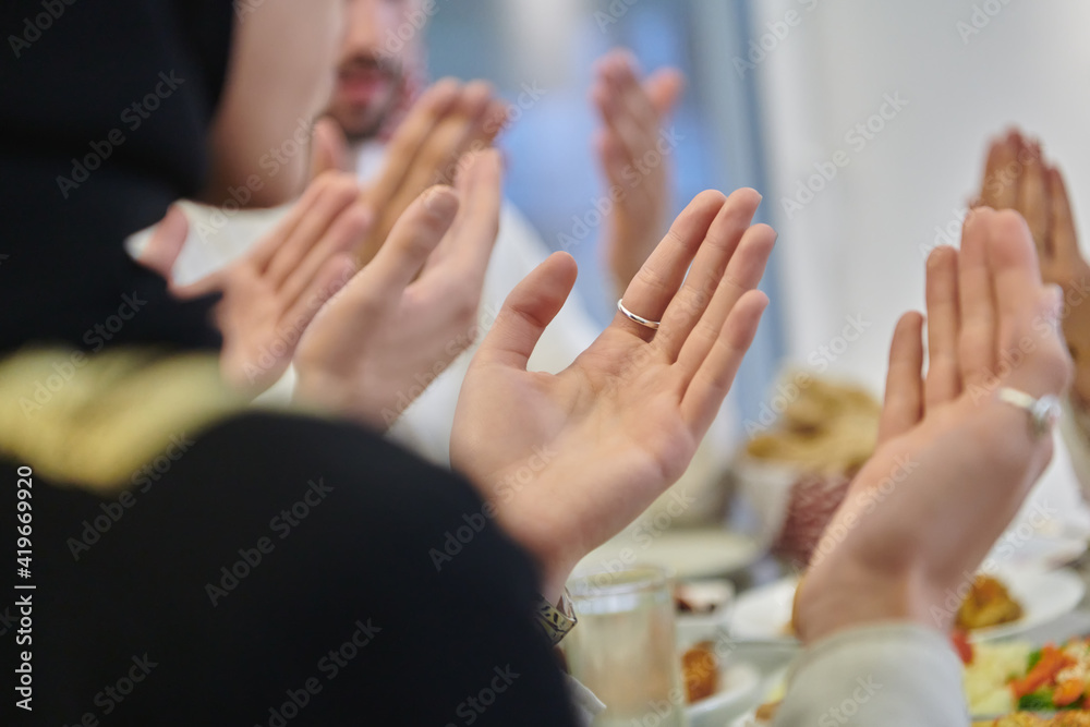 Fototapeta premium Muslim family making iftar dua to break fasting during Ramadan
