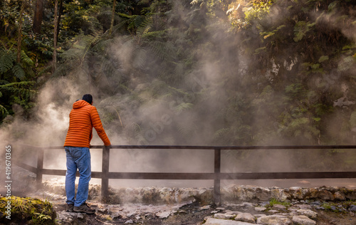 Man visiting Caldeira Velha, hot springs, Azores travel destination.