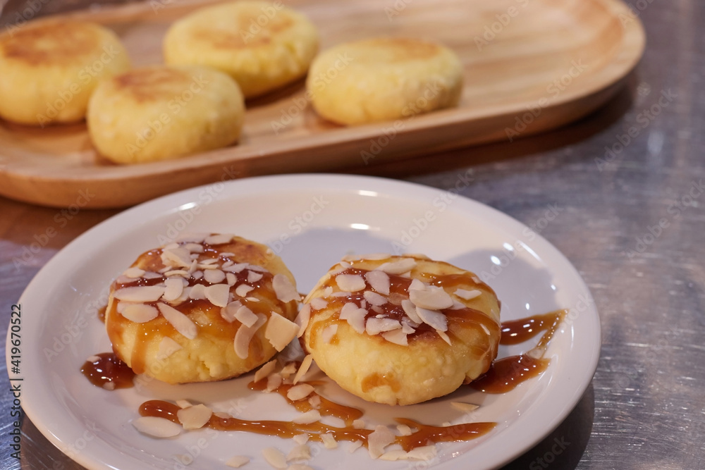 ready fried cheesecakes lie in a plate on a tray on the table the background is blurred