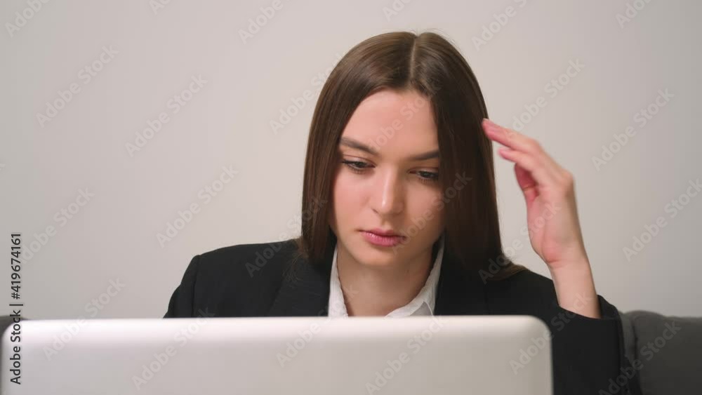 Close up. Portrait of tired sad businesswoman face looking at laptop at the home office. Close up of upset woman thinking about mistakes in work. Portrait of sad girl looking laptop. Depressed Close up. Portrait of tired sad businesswoman face looking at laptop at the home office. Close up of upset woman thinking about mistakes in work. Portrait of sad girl looking laptop. Depressed