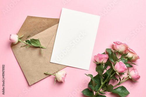 Greeting card mockup with envelope and fresh roses on pink background