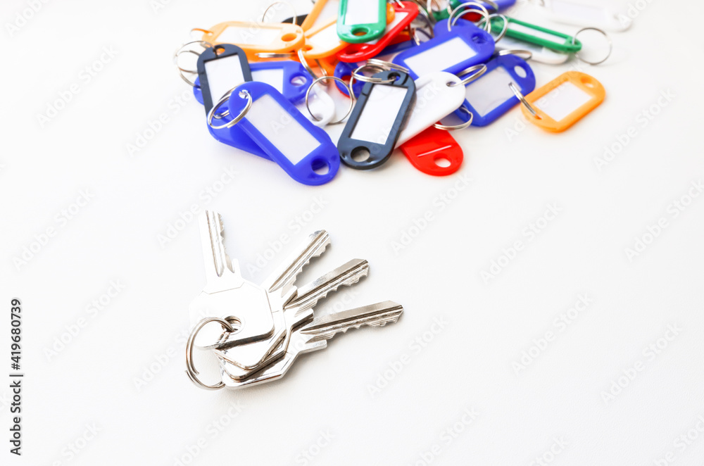 A bunch of keys with key chains of different colors and a place for an inscription on a white background. A bunch of keys with key chains of different colors and a place for an inscription on a white background.
