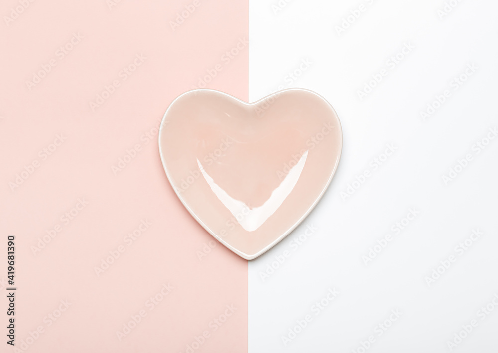 Empty pink heart shaped plate on pink and white background Empty pink heart shaped plate on pink and white background