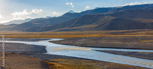 Foto Landscape with a road on  wide floodplain of mountain river.
