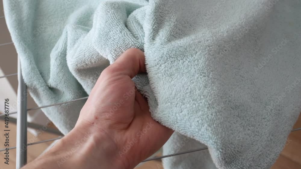 Man touch wet laundry on the clothes dryer after washing in a washer. Daily routine. Man touch wet laundry on the clothes dryer after washing in a washer. Daily routine.