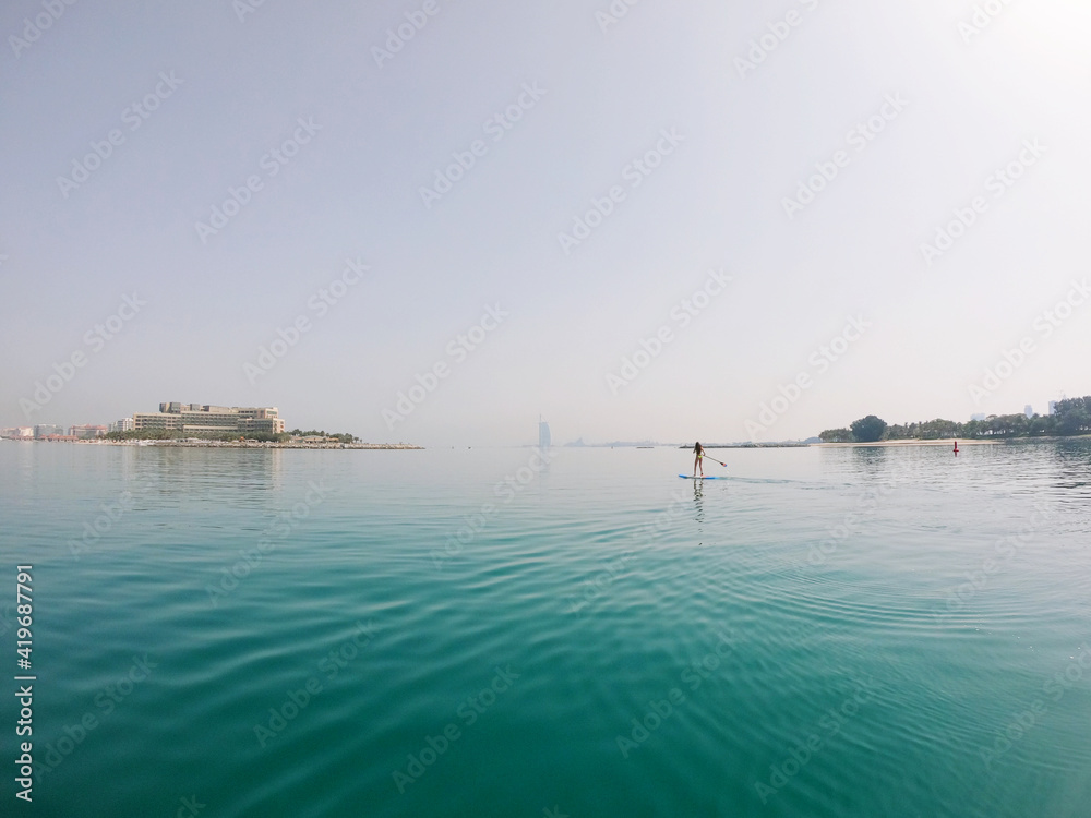 Young woman paddle boarding in Dubai