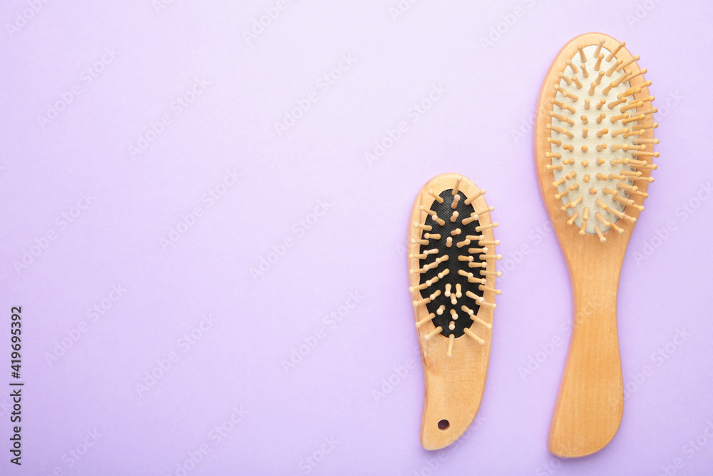 Obraz premium Set of comb and hairbrush on purple background with copy space