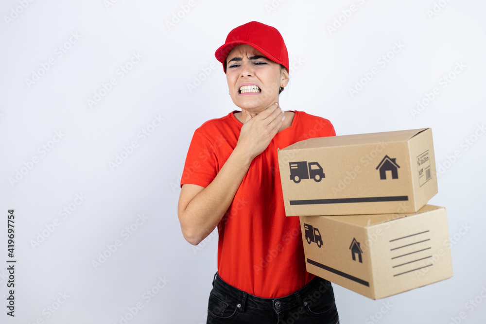 Young beautiful woman wearing courier uniform holding delivery packages touching painful neck, sore throat for flu, clod and infection Young beautiful woman wearing courier uniform holding delivery packages touching painful neck, sore throat for flu, clod and infection