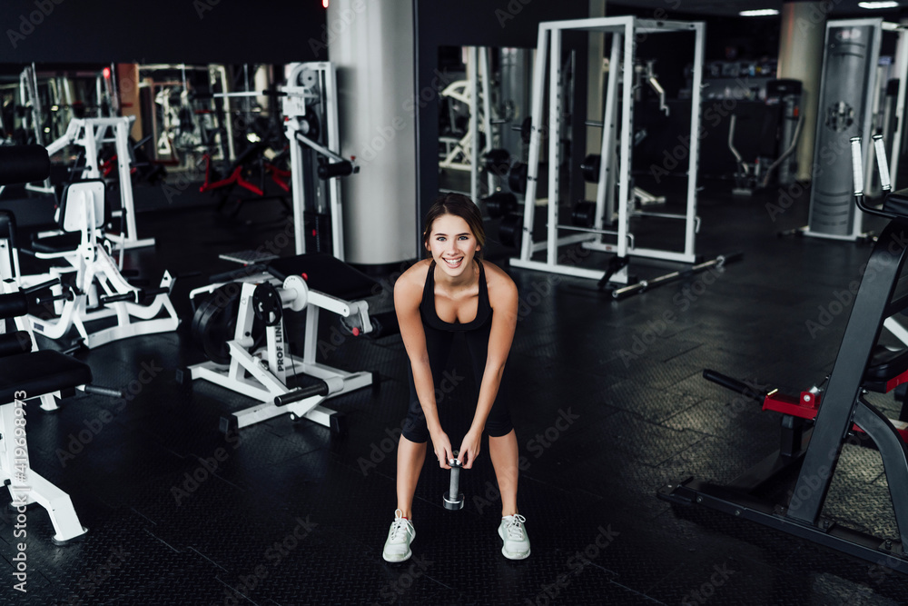 Athletic body, attractive girl in the gym with dumbbells in hand, healthy lifestyle, sports, lifestyle Athletic body, attractive girl in the gym with dumbbells in hand, healthy lifestyle, sports, lifestyle
