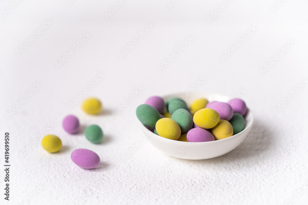 Easter concept. Mini eggs in little plate on white background. Color eggs pattern, easter background. Easter concept. Mini eggs in little plate on white background. Color eggs pattern, easter background.