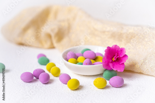 Colorful easter eggs and flower with plate on white desk. Top view  horisontal. Poster  mock up for design. Selective focus