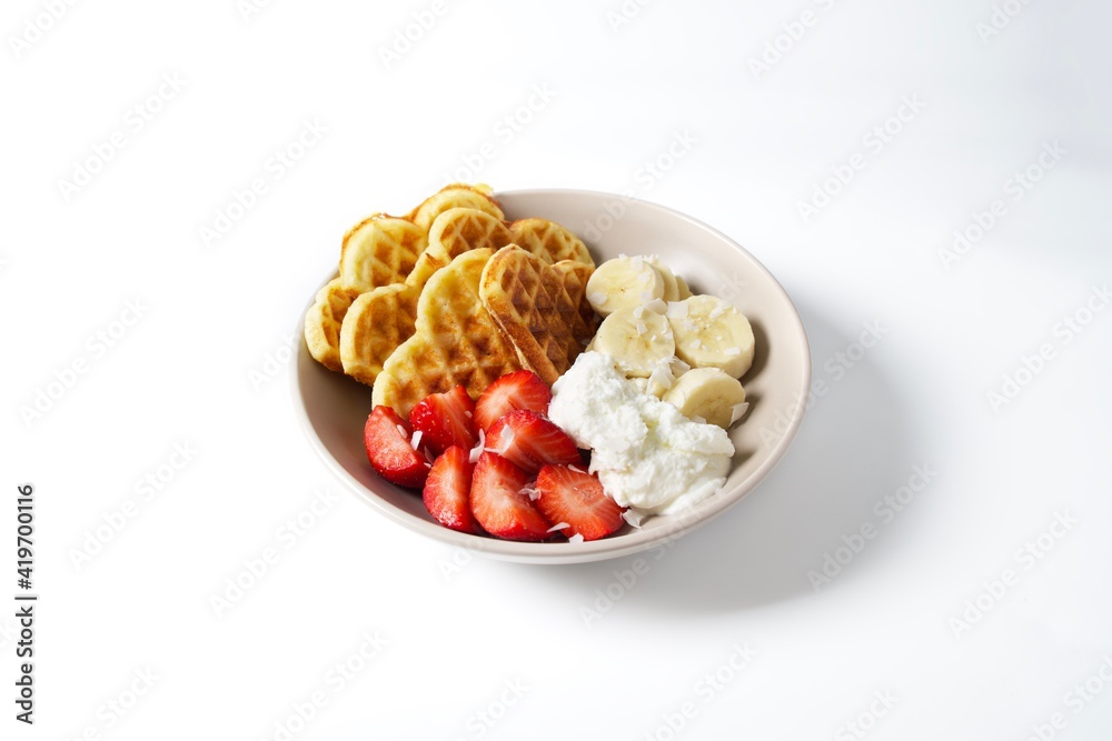 Bowl with Belgian waffles, Greek yogurt, fresh strawberries, banana and coconut flakes Bowl with Belgian waffles, Greek yogurt, fresh strawberries, banana and coconut flakes