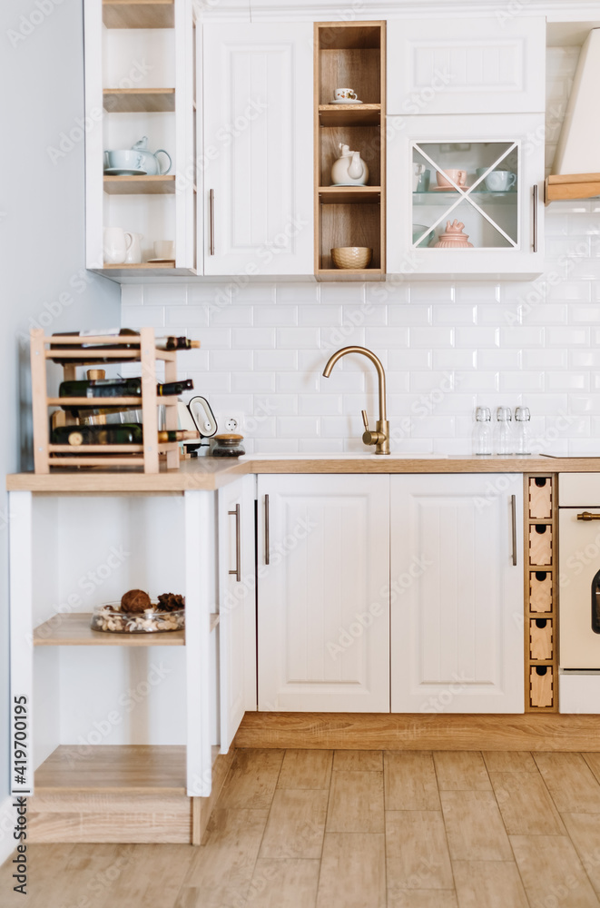 Bright kitchen in the Scandinavian style with dishes and kitchen accessories on the table. Bright kitchen in the Scandinavian style with dishes and kitchen accessories on the table.