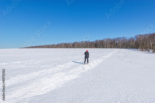 Man goes skiing on the snowdrift surface at sunny day.
