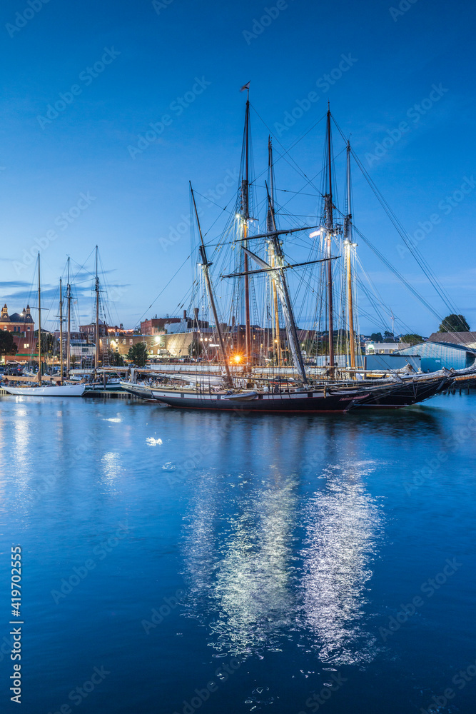 USA, Massachusetts, Cape Ann, Gloucester. Gloucester Schooner Festival, schooners in Gloucester Harbor at dusk