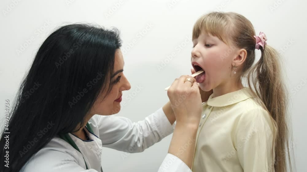 Little girl having a check up at pediatrician. The doctor is pulping and checking child's breathing, hearing and throat. Little girl having a check up at pediatrician. The doctor is pulping and checking child's breathing, hearing and throat.