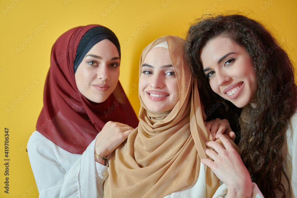 Young muslim women posing on yellow background