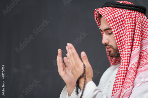 Arab man in traditional clothes praying to God or making dua