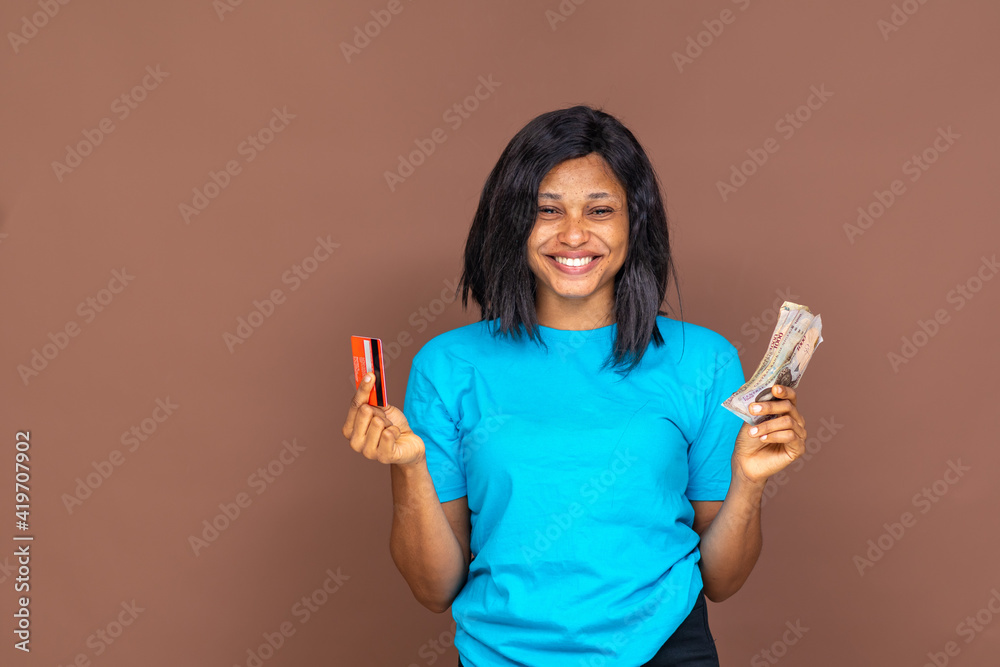 beautiful african woman holding cash in one had and a credit card in the other hand beautiful african woman holding cash in one had and a credit card in the other hand