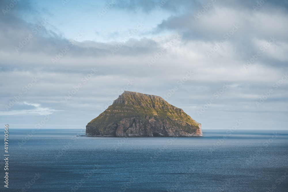 Picturesque green cliffs on Litla Dimun island and atlantic ocean in Faroe islands.