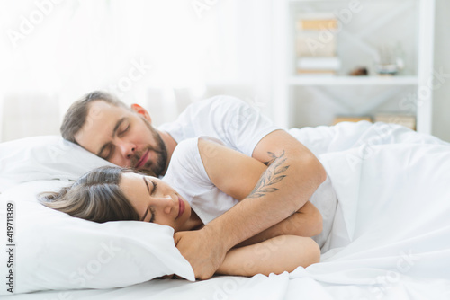 Close up of young couple lying in bed sleeping together at the sunny morning © wpadington