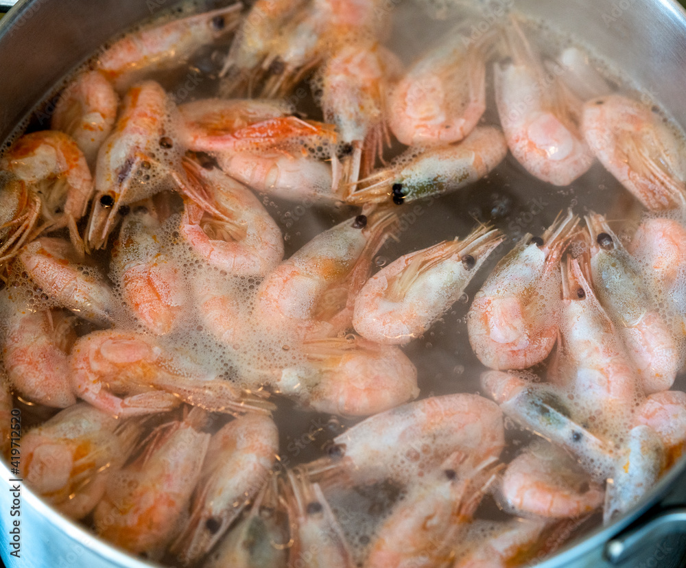 The prawns are boiled in a saucepan on a gas stove. The prawns are boiled in a saucepan on a gas stove.