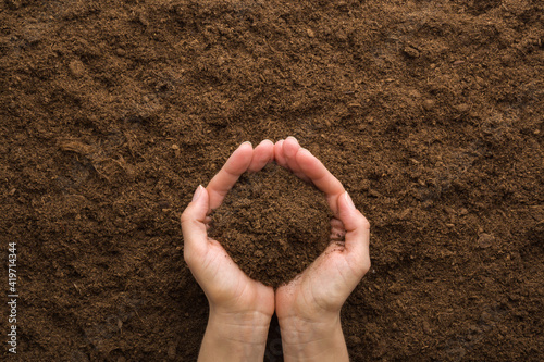 Young adult woman palms holding pile of dark brown dry soil. Care about environment or agriculture. Closeup. Point of view shot. Top down view.