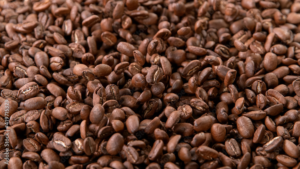 Falling Roasted Coffee Beans on Brown Background, close-up. Falling Roasted Coffee Beans on Brown Background, close-up.