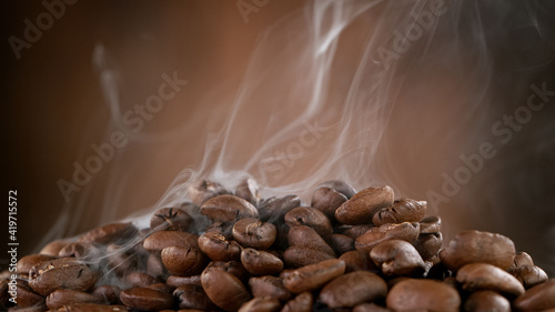 Falling Roasted Coffee Beans on Brown Background, close-up.
