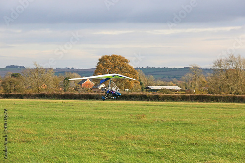 Canvas-taulu Ultralight airplane landing on a grass strip