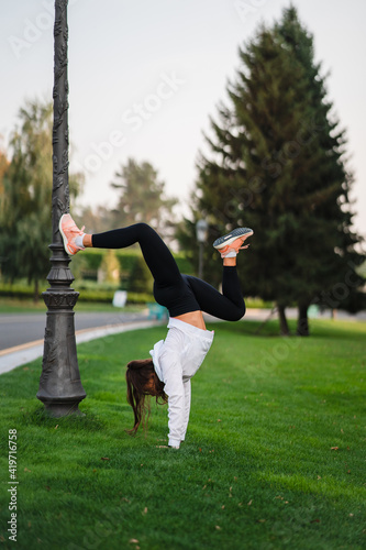 Attractive skinny woman doing a backbend while showing a somersault.