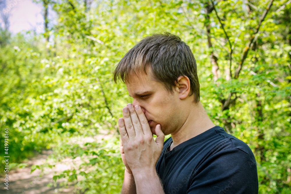A man sneezes in a grove. Allergy concept A man sneezes in a grove. Allergy concept