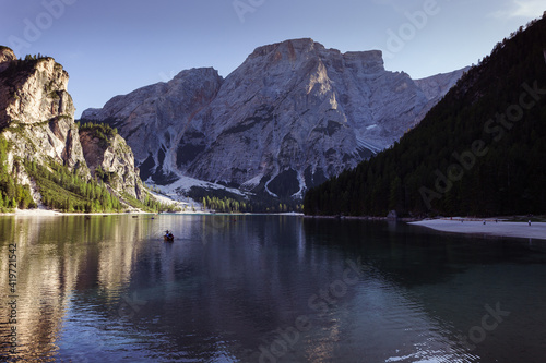 Rowing boat in the Braies lake, with the magnificent Dolomite wall of the Croda del Becco at sunset in the background, South Tyrol, Italy.Concept: relaxation in nature, famous natural places