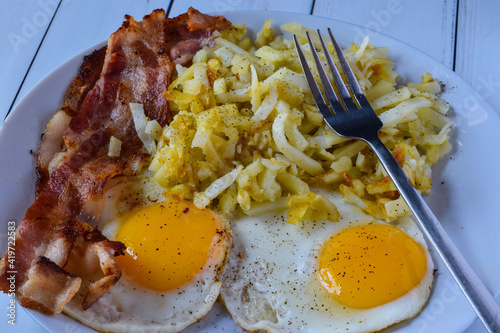 breakfast plate of bacon eggs fried eggstop with pepper photo