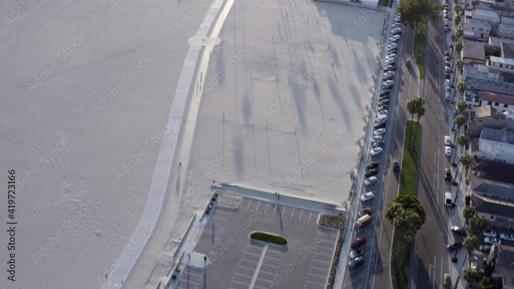 Aerial Forward: Long Wide Sandy Beach Between Neighborhoods And Water Under A Glorious Sunset Sun Aerial Forward: Long Wide Sandy Beach Between Neighborhoods And Water Under A Glorious Sunset Sun