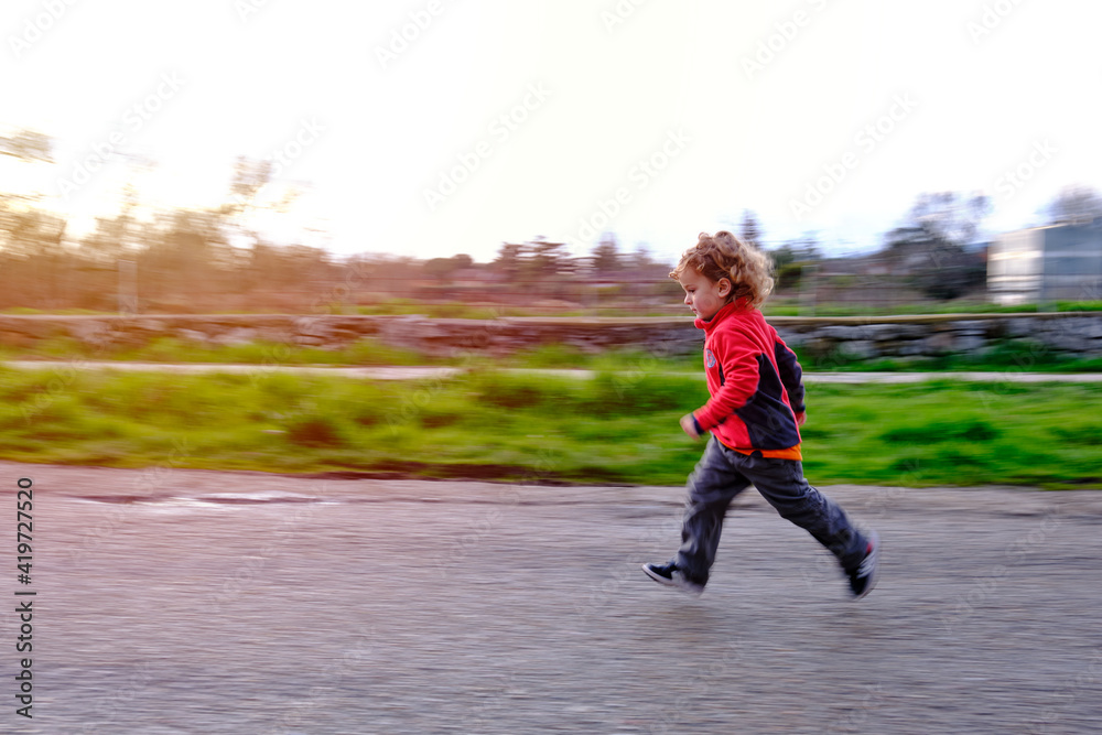 Child running on road on a sunny day. Abstract panning action shot with  motion blur. Stock Photo | Adobe Stock