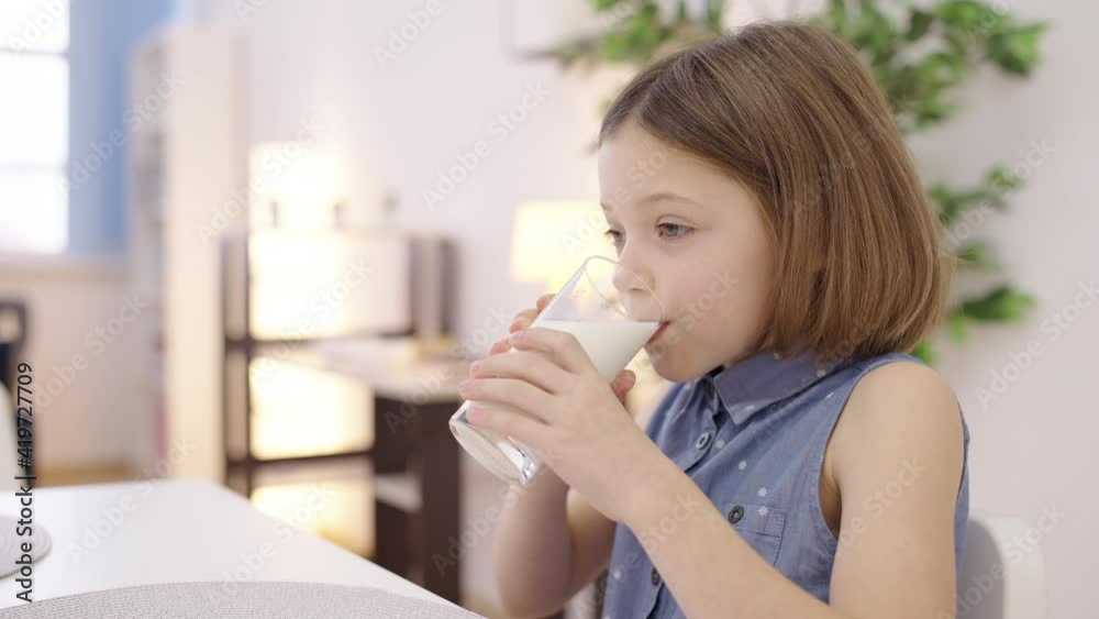 Smiling pretty girl drinking flavored organic milk from glass, health care Smiling pretty girl drinking flavored organic milk from glass, health care