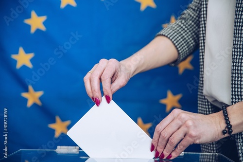 Election in European Union - voting at the ballot box. The hand of woman putting her vote in the ballot box.