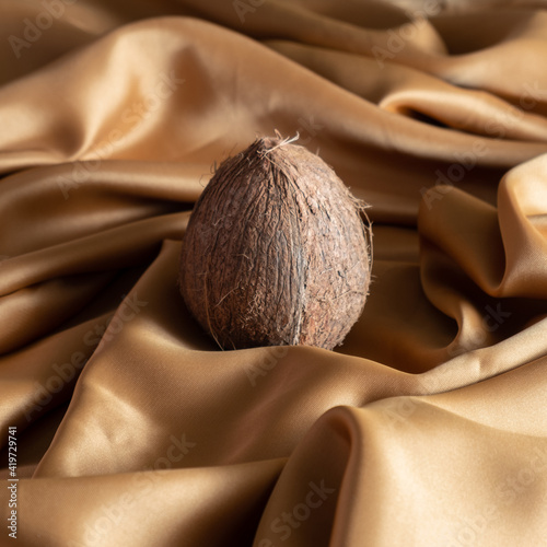 Creative backgroundmade with  coconut and gold silk sheet. Minimal composition photo