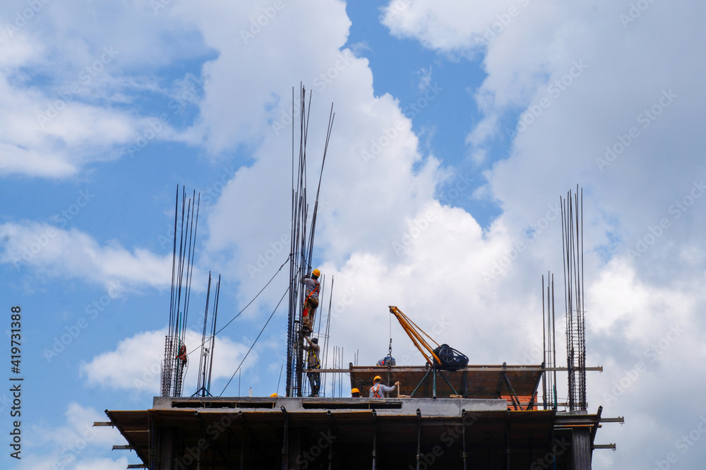 Fototapeta premium Workers on the top of a building under construction