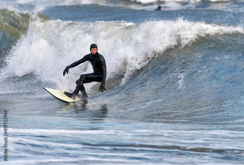 Mid adult man wearing wetsuit surfing on sea, Broad Haven South Beach, Wales, UK