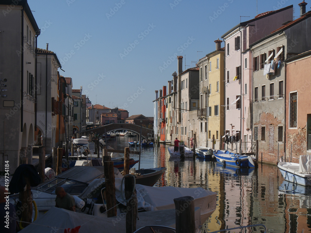 Chioggia, Vena Canal with colorful buildings and crossed by bridges reflected in the water