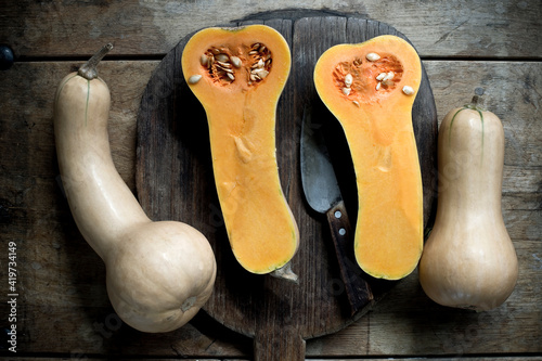 Butternut pumpkins (Cucurbita moschata) cut in halves against rustic background