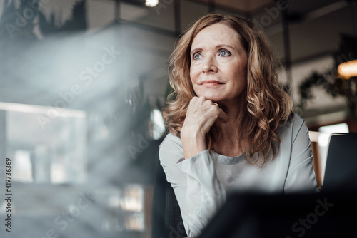 Thoughtful businesswoman with hand on chin at office