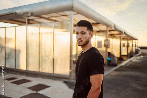 Serious man staring while standing at car wash station