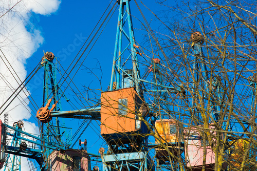 Industrial landscape, cranes, pipes with smoke. Air pollution from smokestacks, ecological problems.