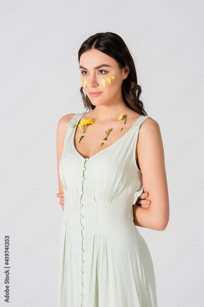 young woman with petals on face and plasters with yellow flowers on body isolated on white young woman with petals on face and plasters with yellow flowers on body isolated on white