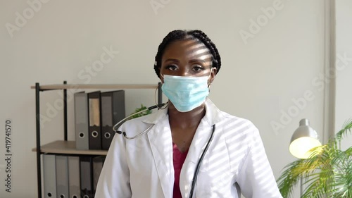 African American woman doctor puts on a mask